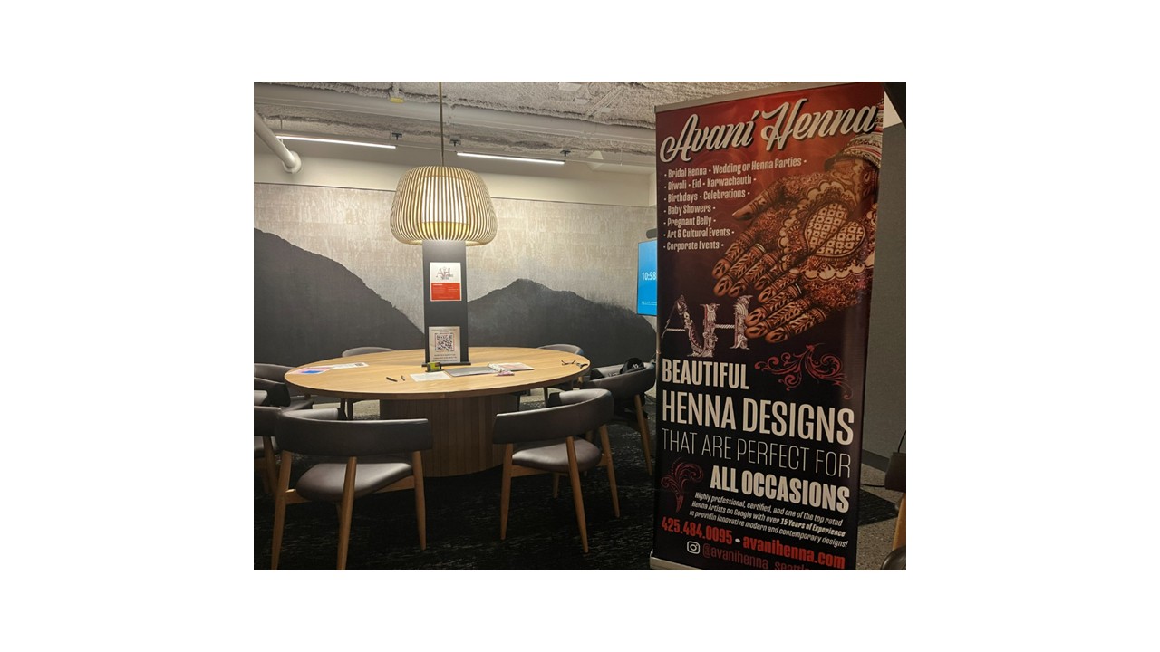 Avani Henna branded booth setup with promotional banner and table at a corporate office event