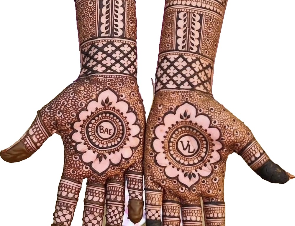 Intricate bridal henna on both hands and forearms with mandala palm centerpieces and lattice patterns