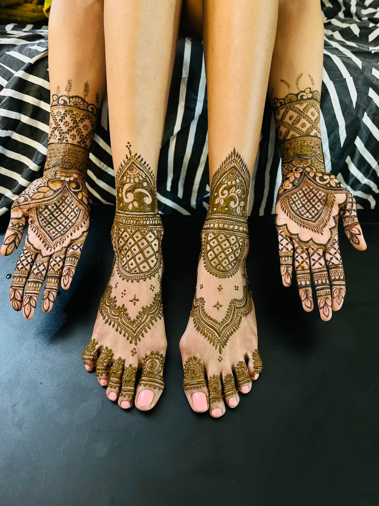 Full bridal henna on both hands and feet with peacock, lotus, and crosshatch motifs