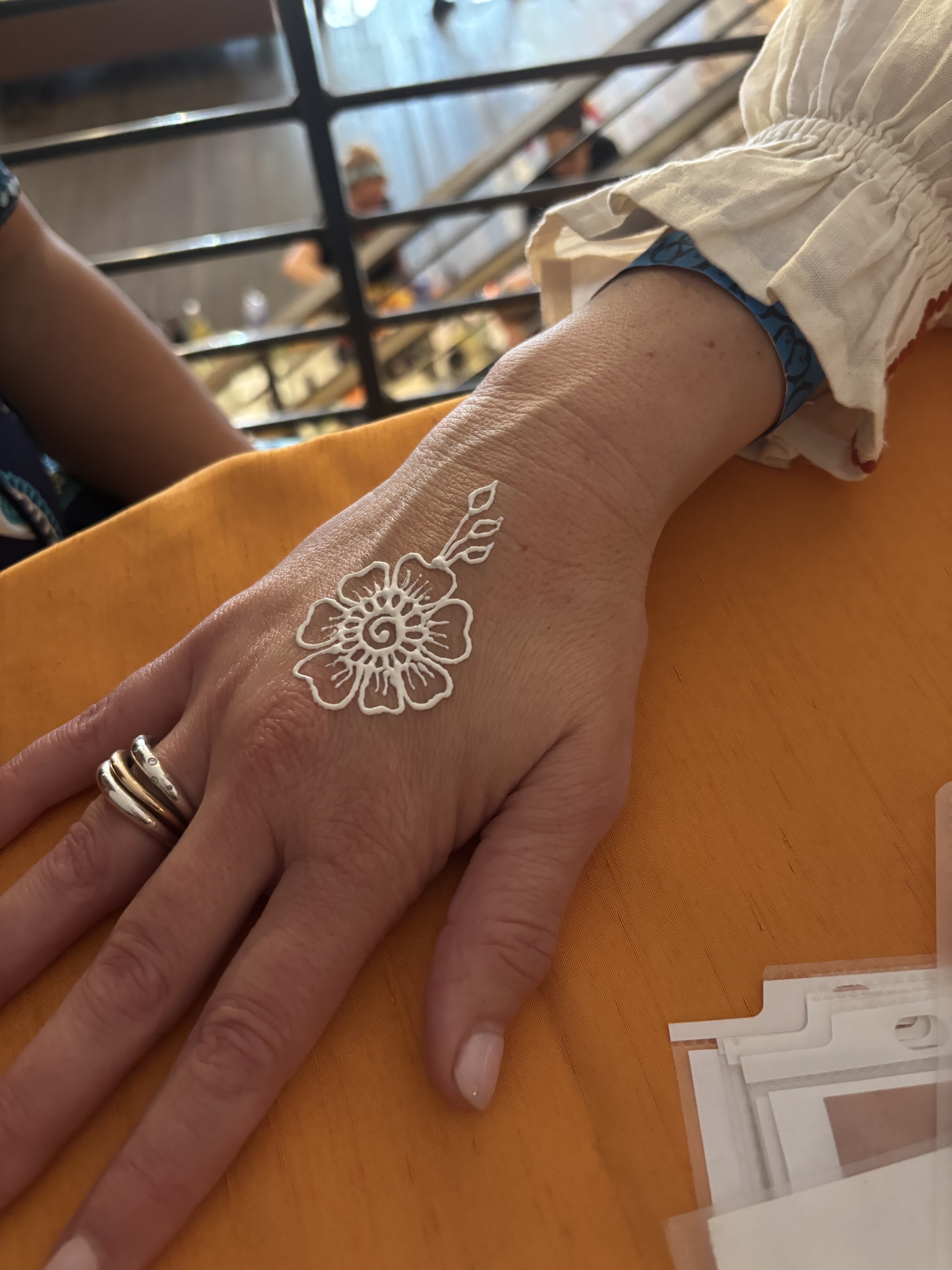 White henna floral design on the back of a hand