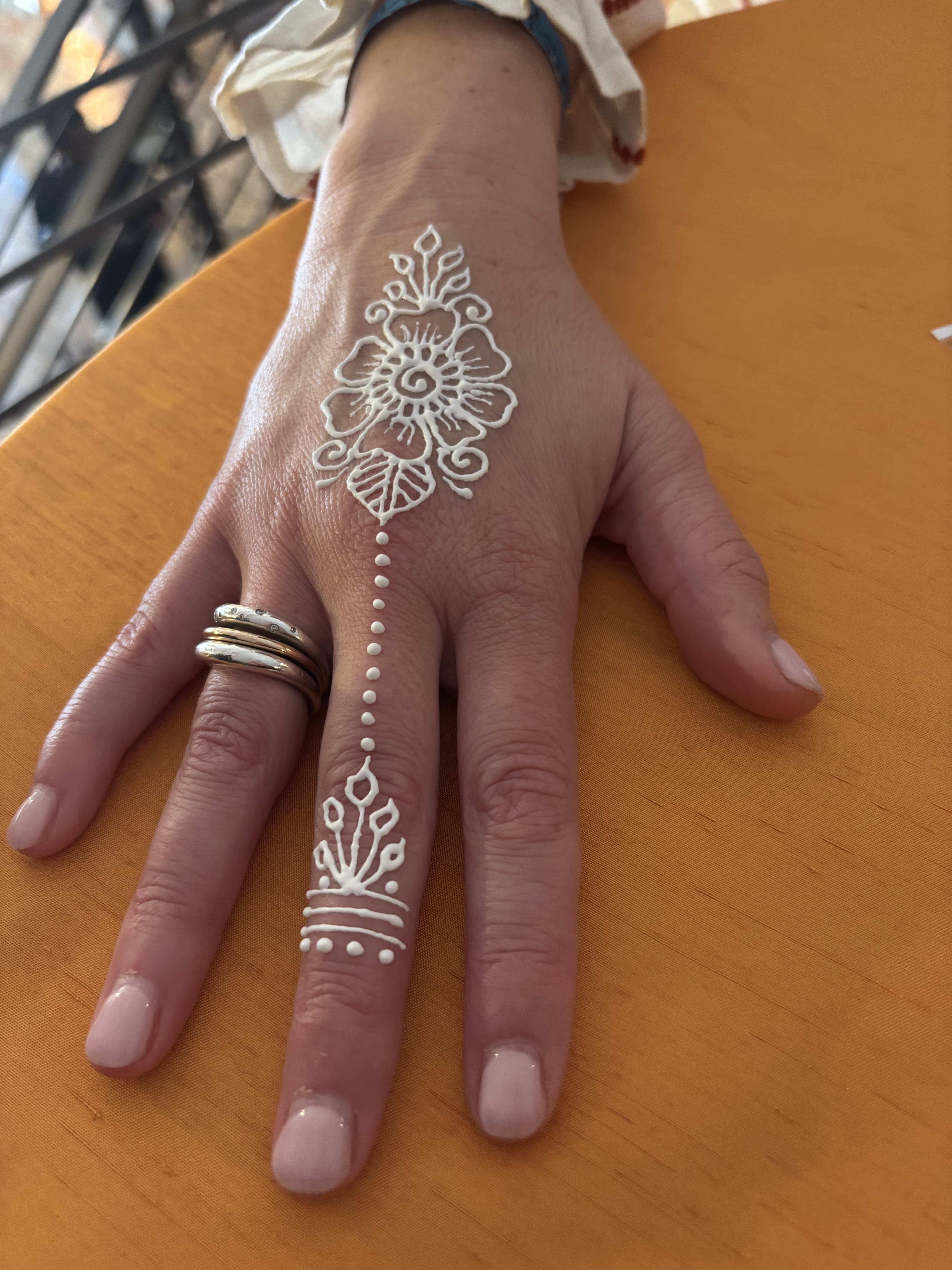 White henna design on hand and fingers
