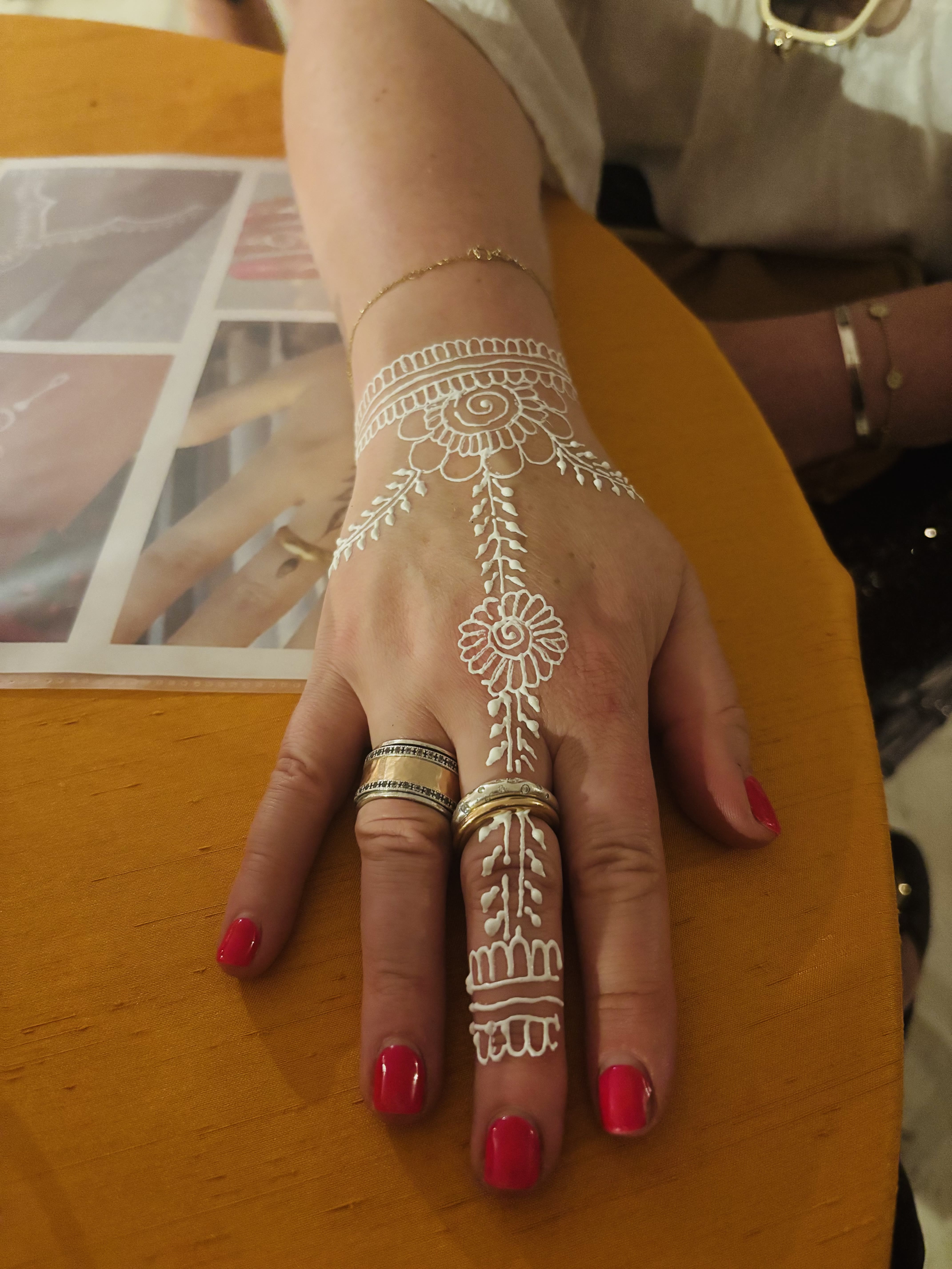 White henna wristband and finger design on a hand